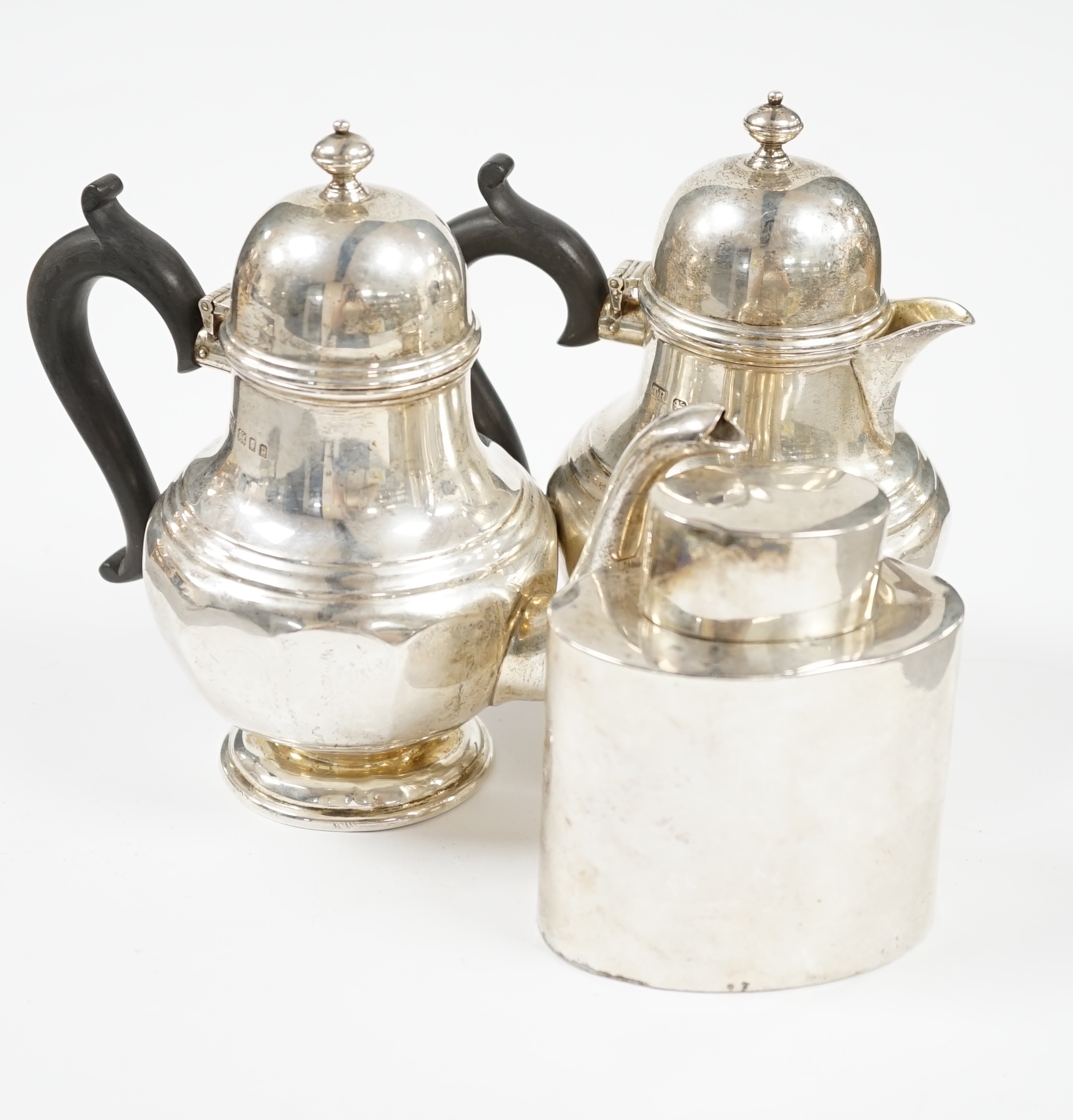 A George V silver bachelors pear shaped café au lait pair, by Theodore Rossi, London, 1930 and an earlier silver tea caddy, gross weight 18.5oz. Condition - poor to fair